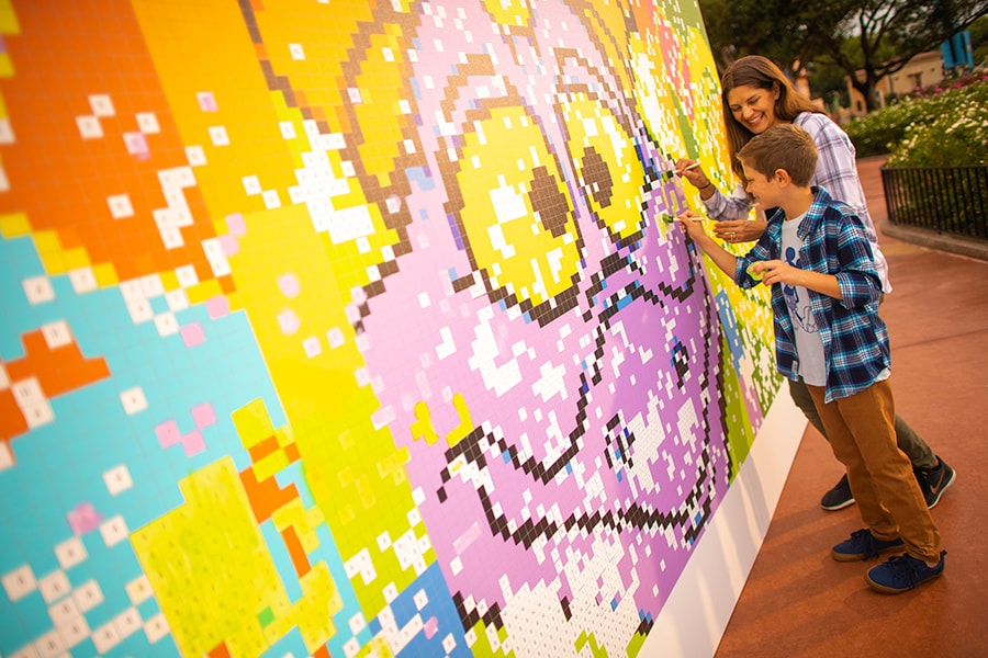mural de pintura coletiva no Epcot com um menino e uma mulher pintando com pincéis