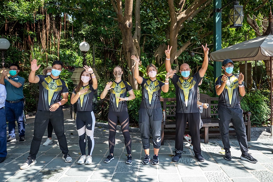 Hong Kong Disneyland cast members waving to athletes