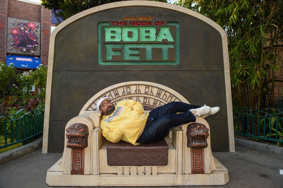 Guest sitting in a replica throne for Boba Fett at Downtown Disney