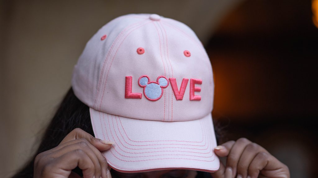 pink baseball cap that reads "love" with mickey symbol
