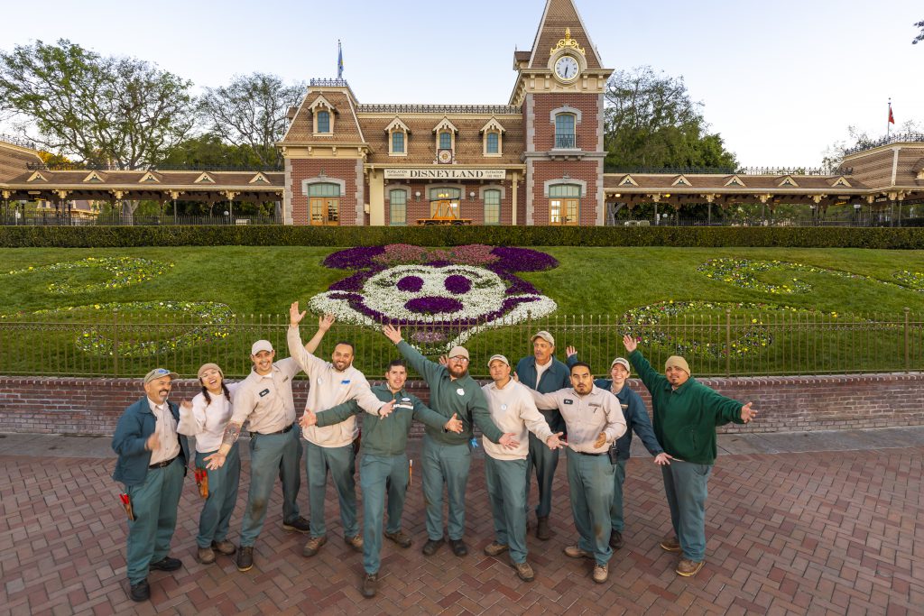 The Horticulture team poses in front of Floral Minnie at the Disneyland Park entrance
