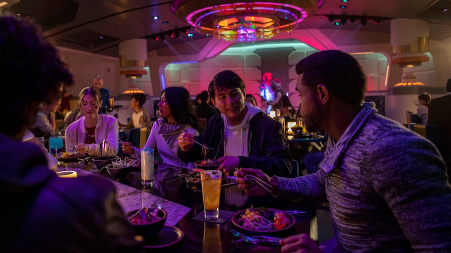 Passengers enjoy the Halcyon starcruiser dining experience in the Crown of Corella Dining Room in Star Wars: Galactic Starcruiser at Walt Disney World Resort