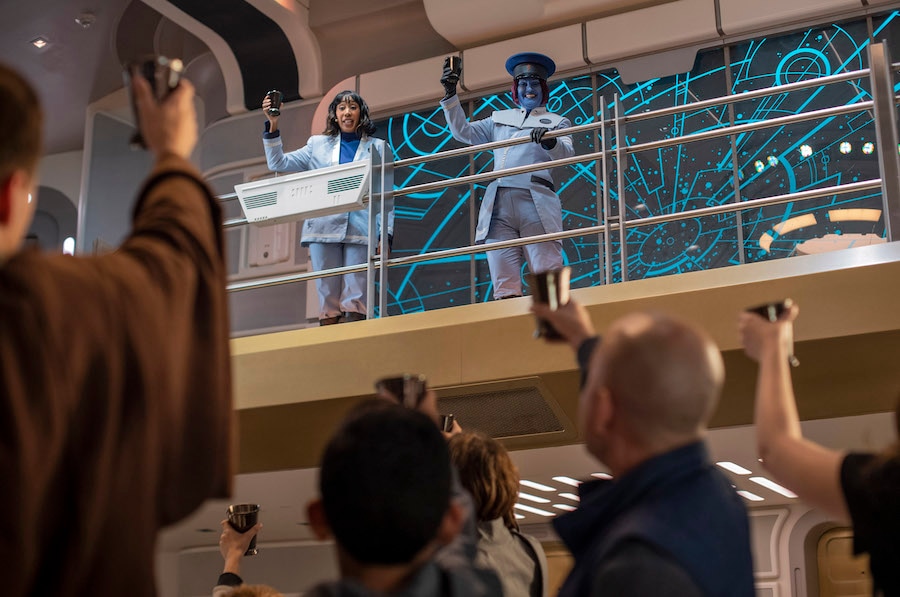 Cruise Director Lenka Mok (left) and Captain Riyola Keevan (right) share a toast with guests in Star Wars: Galactic Starcruiser at Walt Disney World Resort
