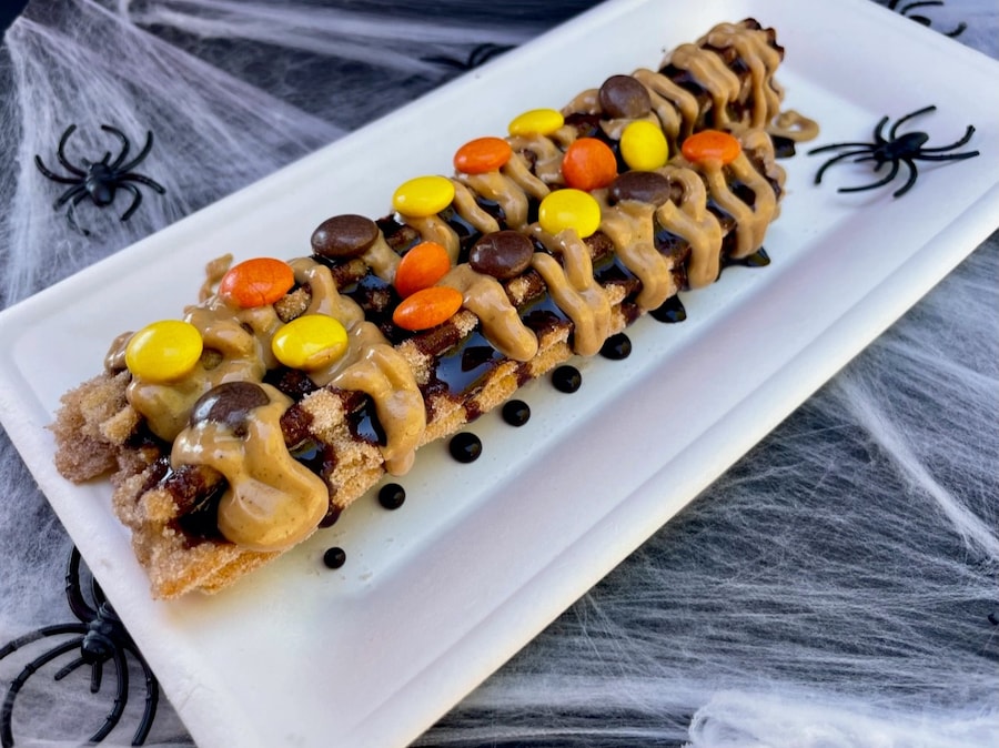 In honor of Halfway to Halloween, guests can visit the Downtown Disney District and try a Spooky Churro, rolled in cinnamon sugar cut in half, drizzled with peanut butter and chocolate sauce, and topped with orange, yellow and brown peanut butter candy pieces from April 28 through May 1, 2022