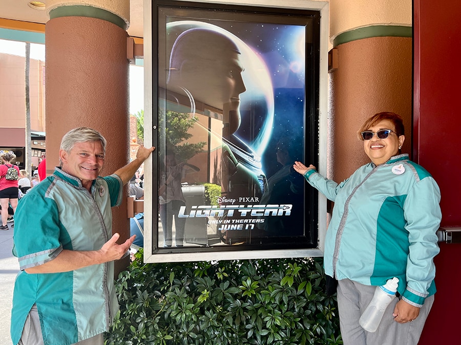 Walt Disney World Resort cast members John and Sidonie in front of a poster for Disney and Pixar's "Lightyear" at Disney's Hollywood Studios