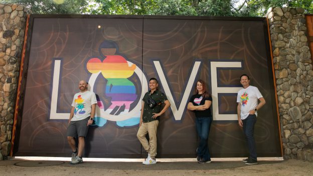 Cast members in front of the Pride-themed wall at Disney's Animal Kingdom