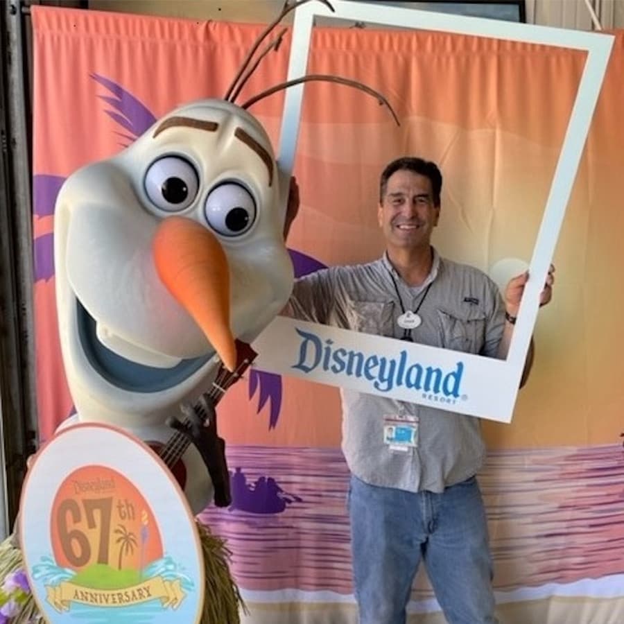 Disneyland Resort cast member posing with Olaf for the 67th anniversary