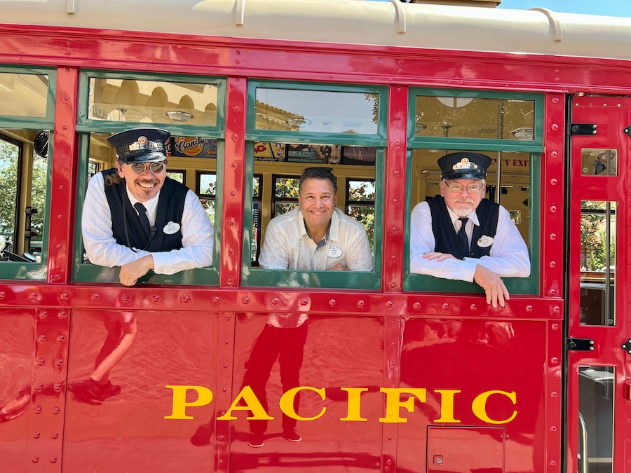 Ken Potrock, President of Disneyland Resort, enjoys a ride on the Red Car Trolley with a couple cast members