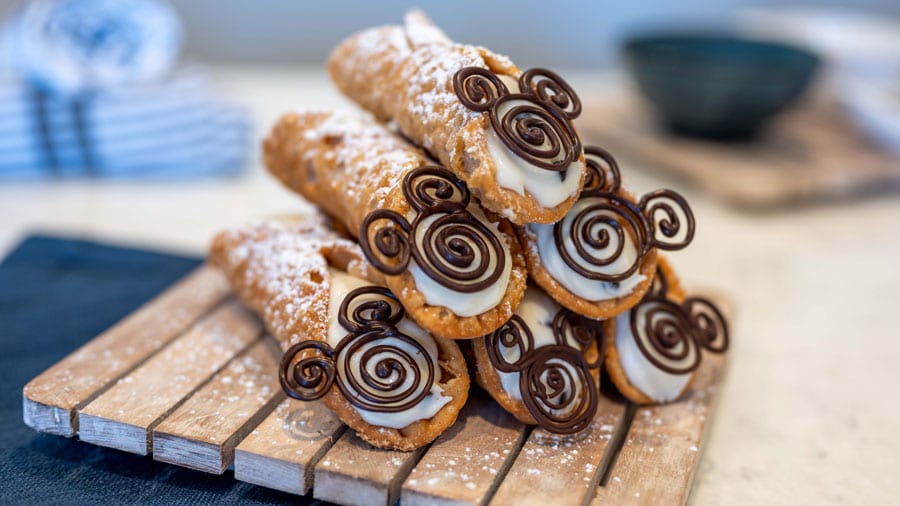 Picture of the Cannolis which are filled to order in a crispy shell with a creamy blend of mascarpone cheese, ricotta, and shaved dark chocolate, with a hint of lemon zest and a touch of Mickey.
