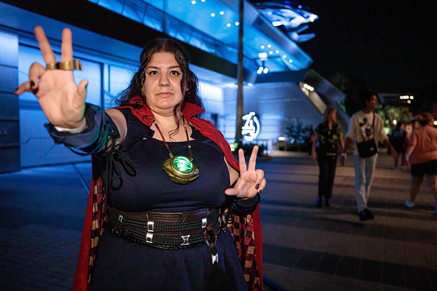 A female cast member poses in Avengers Campus wearing an outfit inspired by Doctor Strange