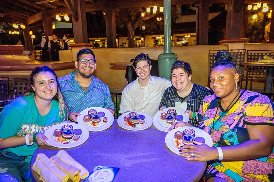 Cast members show off plates of sweet treats at the Oogie Boogie Bash dessert party