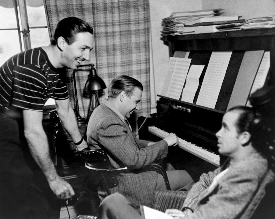 Walt Disney checks in on songwriters Leigh Harline (at the piano) and Ned Washington during the production of PINOCCHIO in 1939.