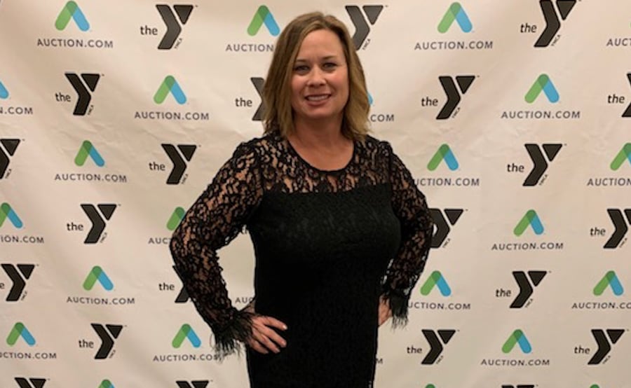 Tracy in front of a YMCA photo backdrop