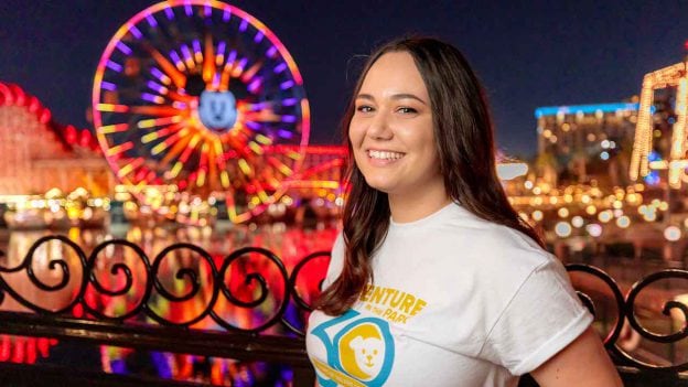 Marisa Morino smiles standing in front of Pixar Pier at night