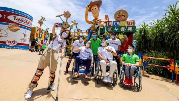 A group of cast members with disabilities stop for a selfie in Toy Story Land at Hong Kong Disneyland.