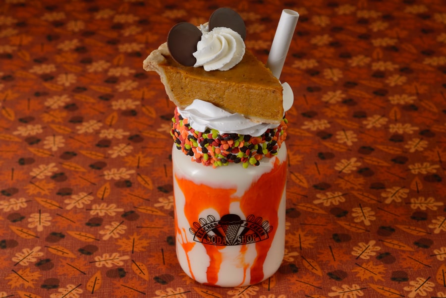 Photo of Pumpkin Pie Shake which is a salted caramel shake with caramel drizzle, sprinkles, and a whole slice of pumpkin pie on top 