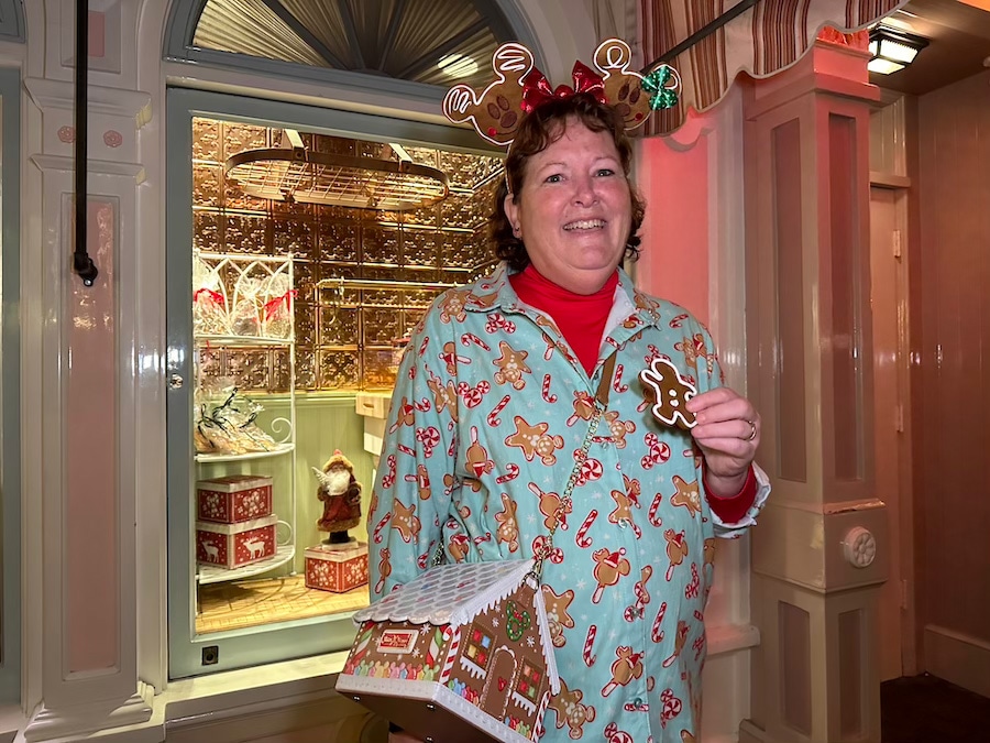 Kim Smith snacks on a gingerbread cookie while wearing gingerbread attire