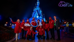 Disneyland Paris cast members in front of castle holding signs