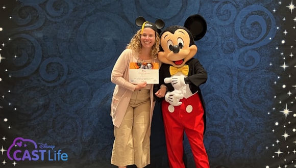 Maria at Disney Institute’s in-person professional development course, Disney’s Approach to Leadership Excellence graduation with Mickey Mouse.
