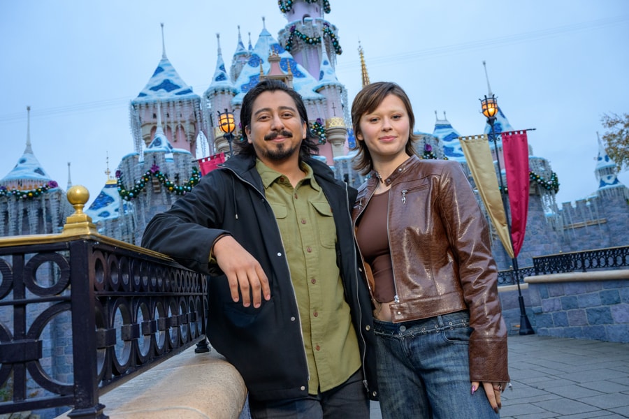 Ruby Cruz and Tony Revolori in front of Sleeping Beauty Castle at Disneyland during the holidays