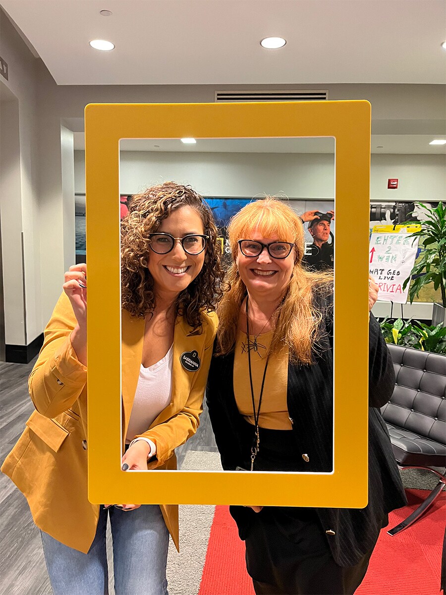 Dawn Kintigh and coworker with Nat Geo sign