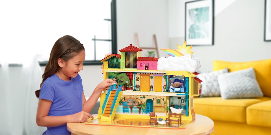 Girl playing with an "Encanto" toy house