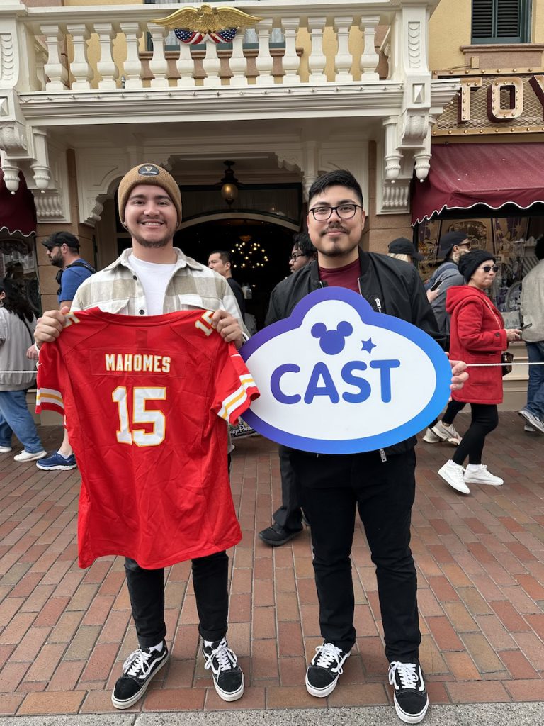 Alejandro Rejin with friend holding Kansas City Chiefs jersey and Cast Life sign