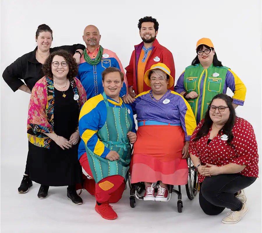 Cast Members wearing a variety of their new costume options pose together.