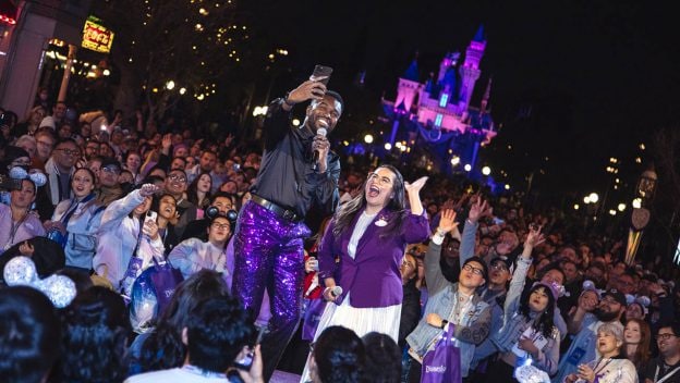 Disneyland Resort Ambassadors speak to a crowd of cast members in front of Sleeping Beauty Castle