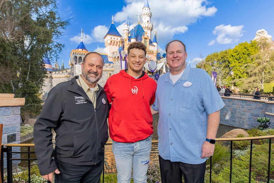 Garett Heffner with Jeff Gibbs pictured with Patrick Mahomes in front of Sleeping Beauty's castle