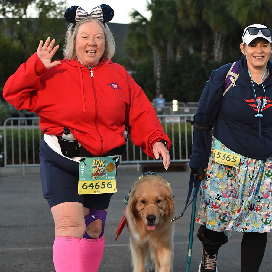 Joan waves as she, Jennifer and Sulley participate in a runDisney race together.