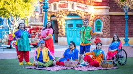 Cast Members in their new costumes pose on a picnic blanket outside Toontown City Hall.