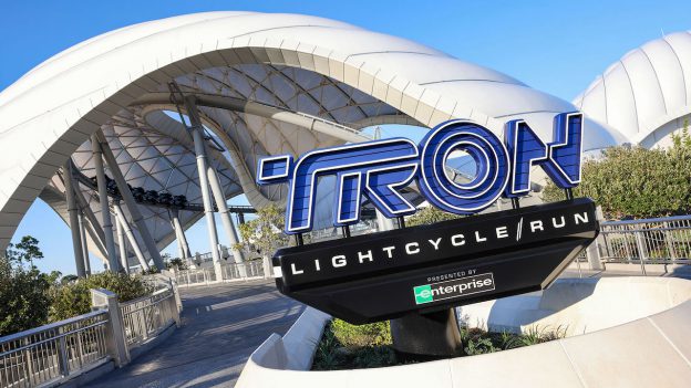 TRON Lightcycle / Run marquee at entrance to attraction with white canopy in the background against a blue sky
