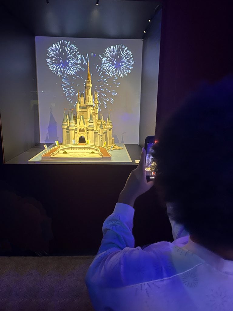 Claire snaps a photo of a model of Cinderella Castle
