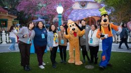 Cast members pose with Pluto and Goofy in a reimagined area of Mickey's Toontown