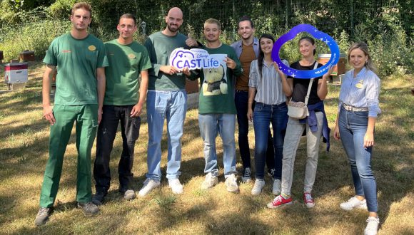 Cast members smile with a Disney Cast Life sign at a Discovering Magic Tour.