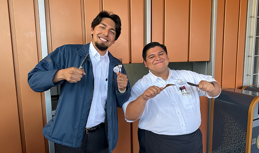 Cast Members Eliceo and Luis hold knives and forks