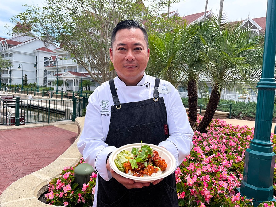 Chef Kevin Chong smiles with his Korean Fried Chicken Bowl with Cucumber Namasu
