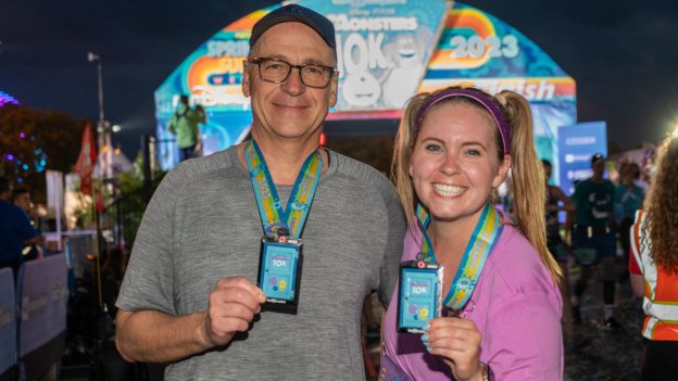 Ali and David showing off medal at the runDisney finish line