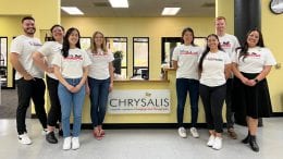 Cast member volunteers stand inside the Chrysalis office