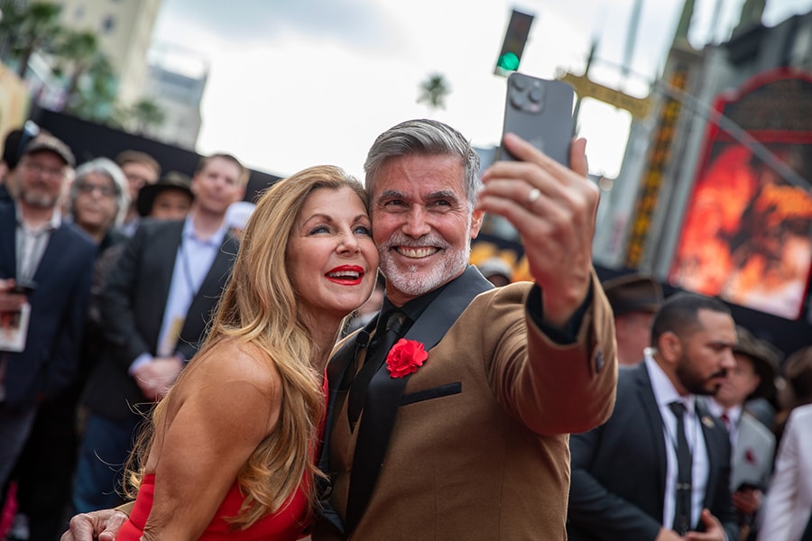 Michele and Kevin smile for a selfie on the red carpet