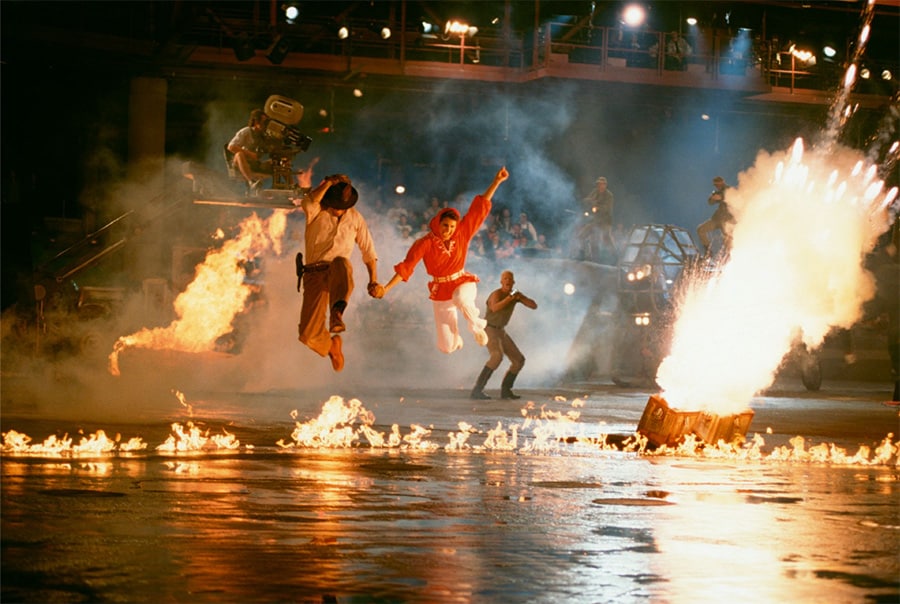 Indiana Jones and Marion jump over fire in the Indiana Jones Epic Stunt Show Spectacular