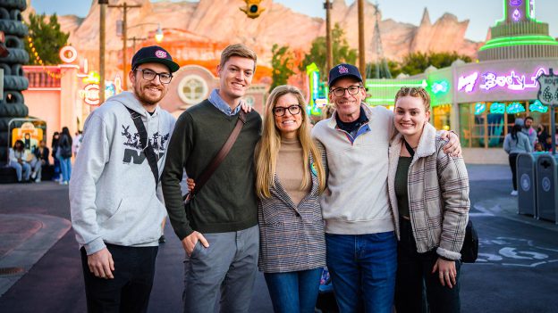 The entire Stoops family smiles together inside Cars Land at Disney California Adventure.
