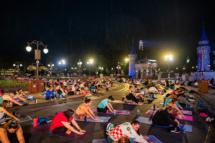 Walt Disney World Cast perform yoga in front of Cinderella Castle