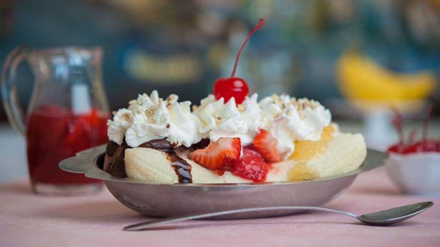 Banana Split with vanilla, strawberry and chocolate ice cream topped with crushed pineapple, strawberries and hot fudge served with a banana, whipped cream, diced almonds and a cherry at Disney Springs