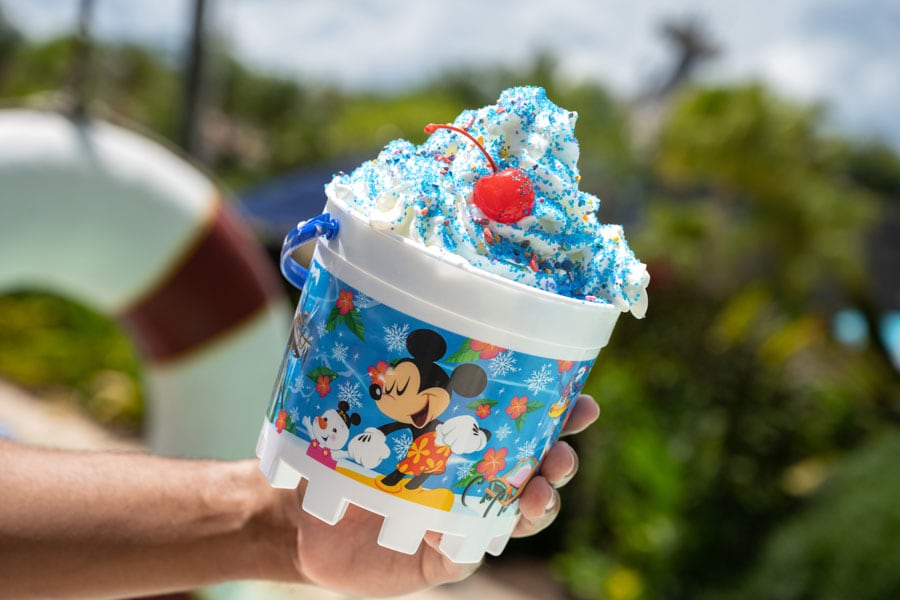 Person holding a sand pail bucket decorated with Disney characters and full of ice cream at Disney’s Typhoon Lagoon Water Park