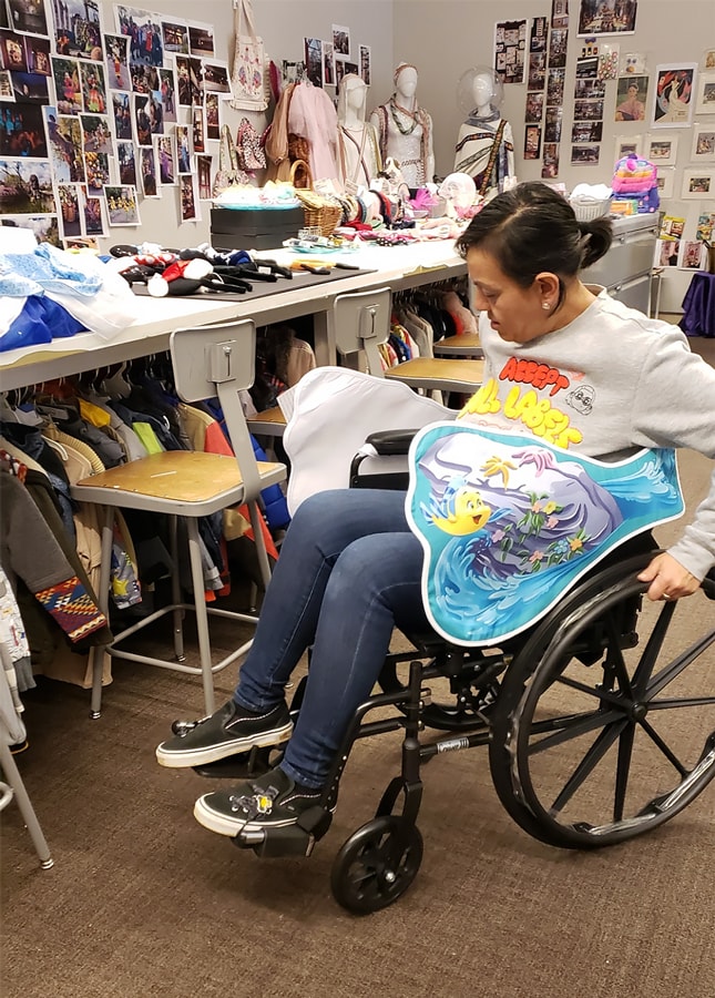 Julia Pita testing out The Little Mermaid Adaptive Wheelchair Wrap