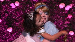 Young female wish kid hugs Cinderella with glee.