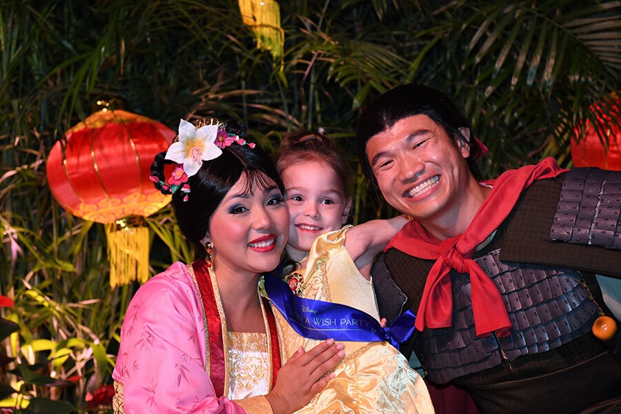 Image of Make-A-Wish kid smiles with Mulan and Li Shang during Disney World Princess Week.