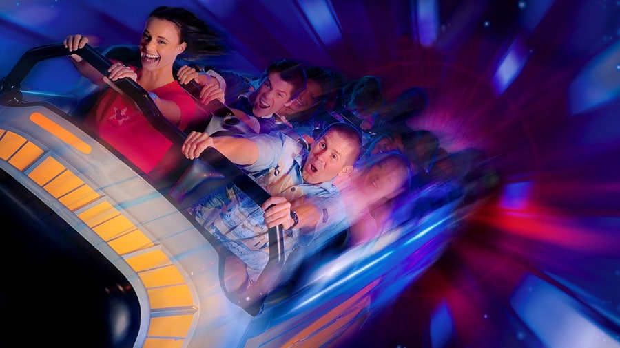 a group of people riding the rollercoaster space mountain at Disney